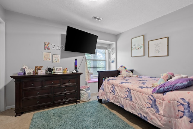 bedroom featuring light colored carpet and a textured ceiling