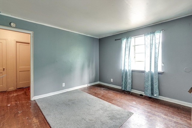 empty room featuring crown molding and hardwood / wood-style flooring