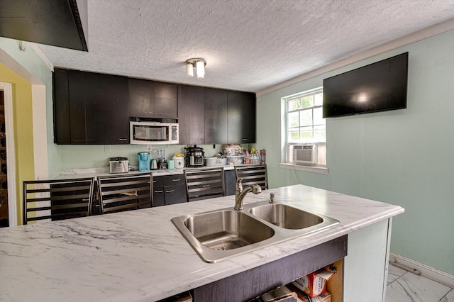 kitchen with a textured ceiling, wine cooler, sink, cooling unit, and a breakfast bar area