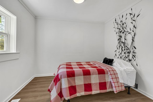 bedroom featuring crown molding and dark hardwood / wood-style floors