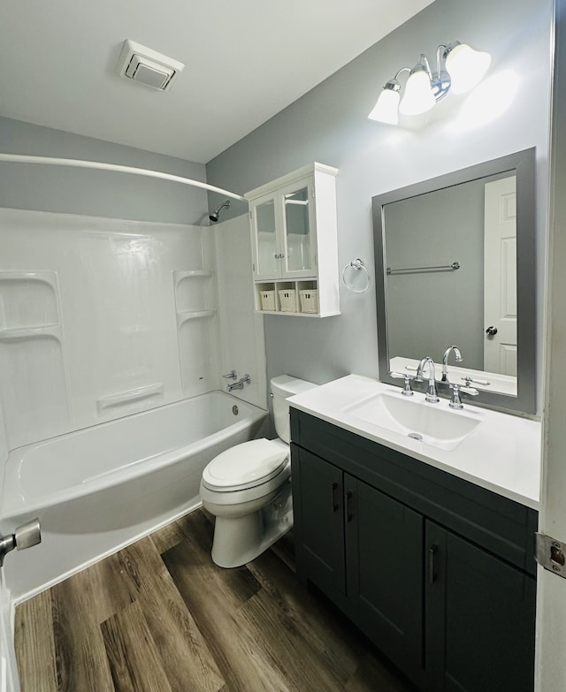 full bathroom with vanity, toilet, hardwood / wood-style flooring, and bathing tub / shower combination