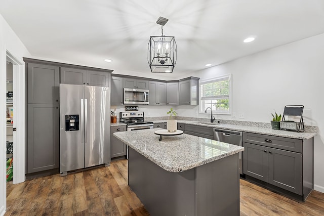 kitchen featuring appliances with stainless steel finishes, dark hardwood / wood-style flooring, sink, gray cabinets, and a kitchen island