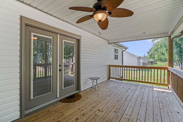 deck with ceiling fan, a lawn, and french doors