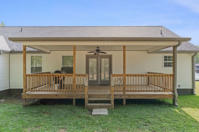 back of property with french doors, a deck, a lawn, and ceiling fan