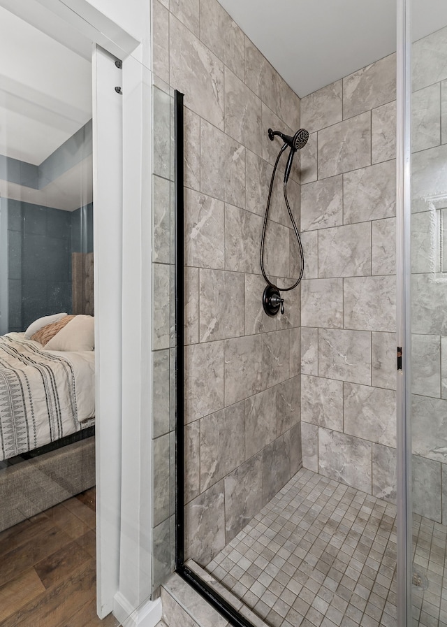 bathroom with wood-type flooring and a tile shower