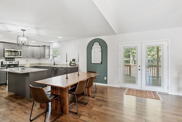 dining space featuring sink, a chandelier, dark hardwood / wood-style flooring, and french doors