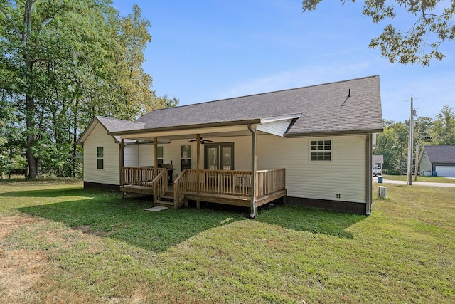 rear view of house featuring a yard, ceiling fan, and a wooden deck