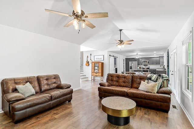 living room with ceiling fan, sink, hardwood / wood-style floors, and vaulted ceiling