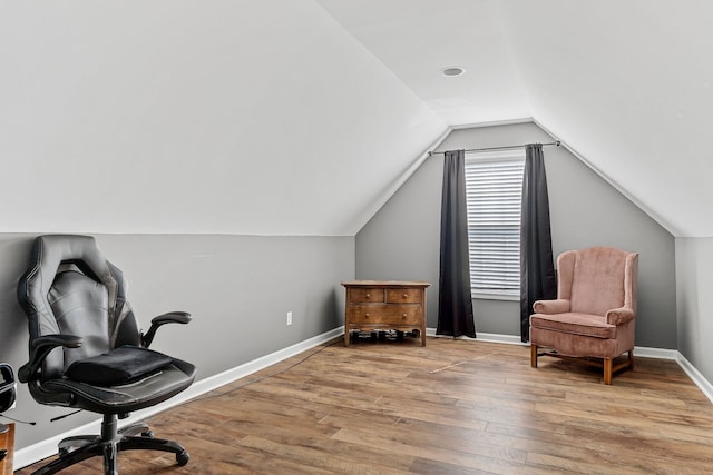 living area with vaulted ceiling and light hardwood / wood-style flooring