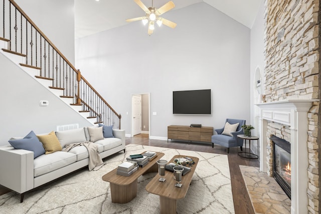 living room with a fireplace, hardwood / wood-style flooring, high vaulted ceiling, and ceiling fan