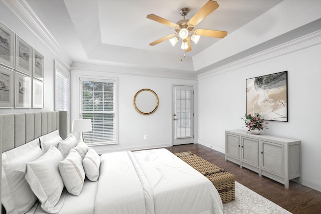 bedroom featuring dark hardwood / wood-style floors, a raised ceiling, and ceiling fan