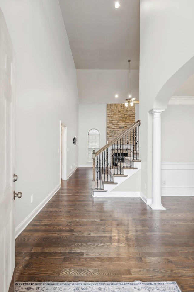 interior space featuring ornate columns, dark hardwood / wood-style flooring, and a towering ceiling