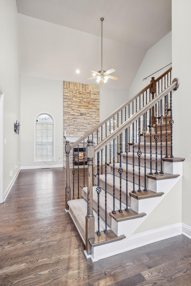 staircase with hardwood / wood-style floors, ceiling fan, and lofted ceiling