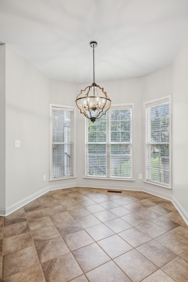 unfurnished dining area with light tile patterned floors and a chandelier