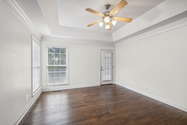 spare room with a tray ceiling, ceiling fan, and dark hardwood / wood-style floors