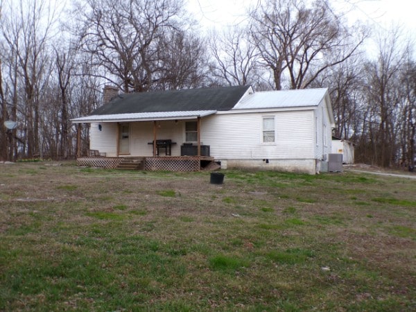 back of property with a lawn and central AC unit