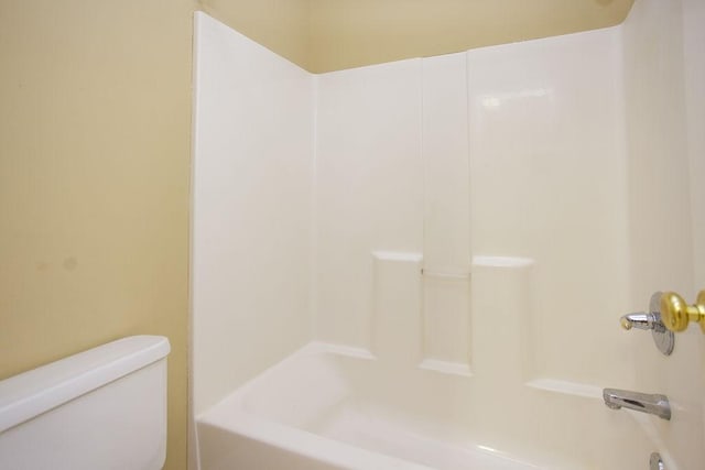 bathroom featuring shower / washtub combination and toilet