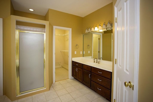 full bathroom with a stall shower, a walk in closet, tile patterned flooring, and vanity