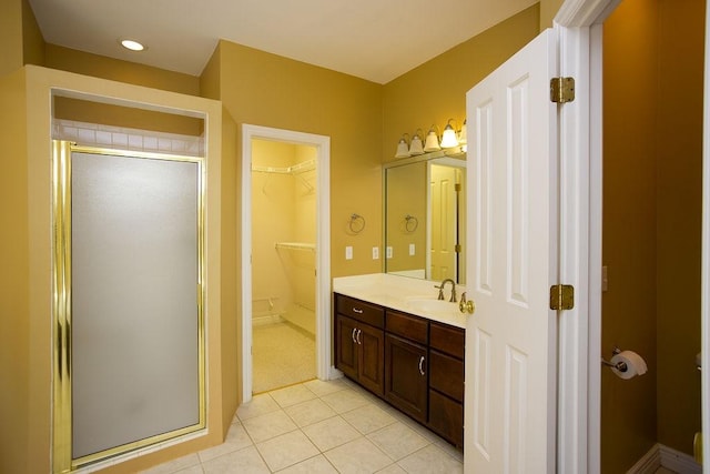 bathroom with a stall shower, tile patterned floors, a spacious closet, and vanity