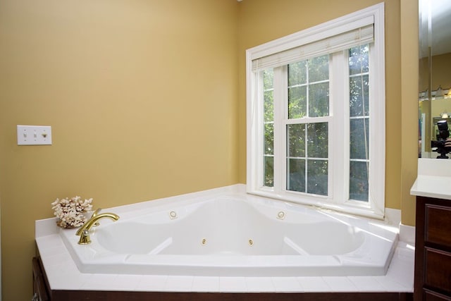 bathroom with tiled tub and vanity