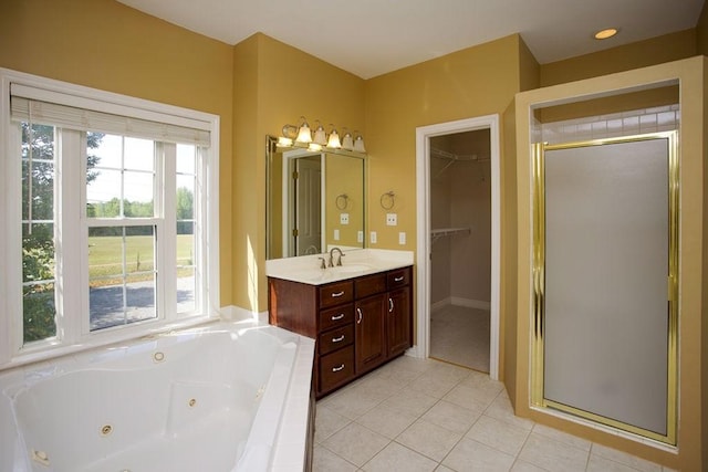 full bath featuring vanity, a spacious closet, a shower stall, a tub with jets, and tile patterned floors