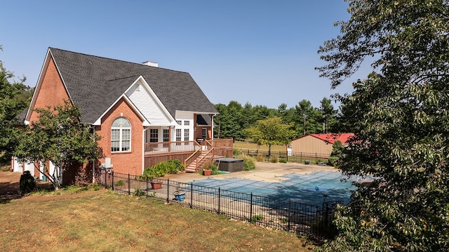 view of side of home with a lawn and a covered pool