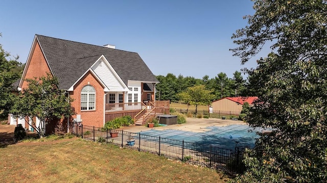 view of swimming pool featuring a patio, a wooden deck, a fenced backyard, a fenced in pool, and a yard