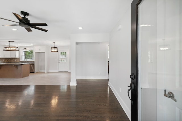 unfurnished living room featuring ceiling fan and hardwood / wood-style floors