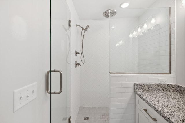 bathroom featuring vanity, tile walls, and walk in shower