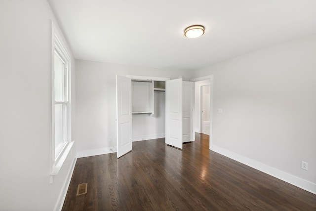 unfurnished bedroom featuring a closet and dark hardwood / wood-style floors