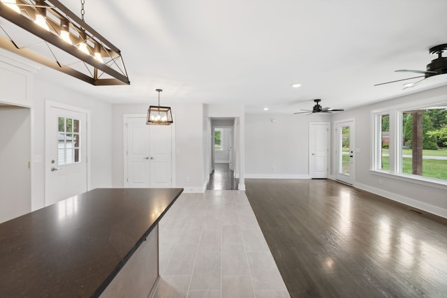 interior space featuring hardwood / wood-style floors and ceiling fan with notable chandelier