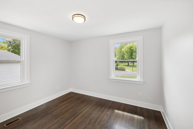 spare room featuring a wealth of natural light and dark hardwood / wood-style flooring