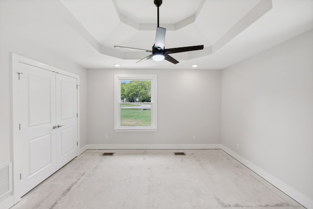 unfurnished bedroom with a raised ceiling and ceiling fan