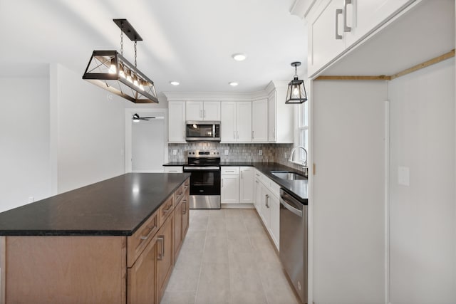 kitchen with white cabinets, appliances with stainless steel finishes, pendant lighting, and sink