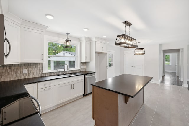 kitchen with a center island, stainless steel appliances, sink, and white cabinetry