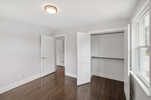 unfurnished bedroom with a closet and dark hardwood / wood-style flooring