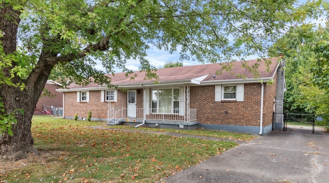 single story home with covered porch and a front yard