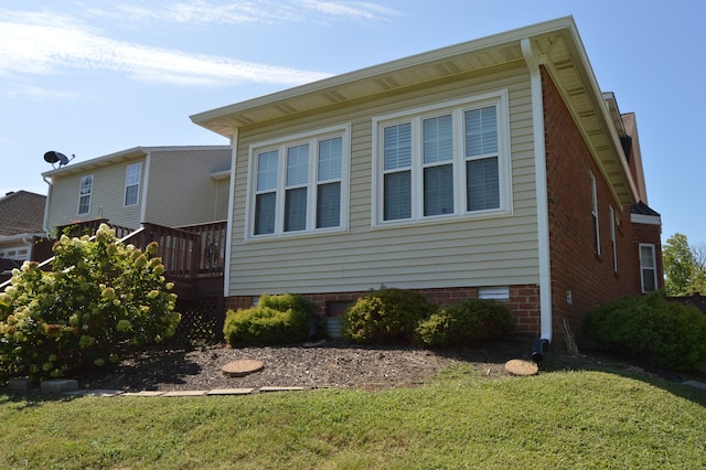 view of home's exterior featuring a wooden deck and a lawn