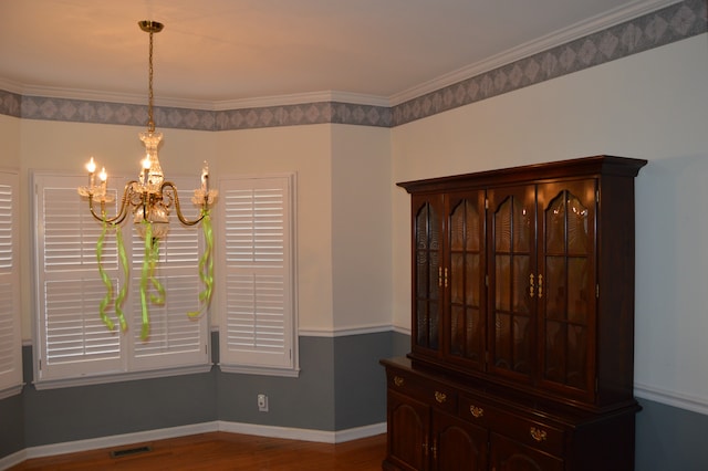 unfurnished dining area with hardwood / wood-style flooring, a chandelier, and crown molding