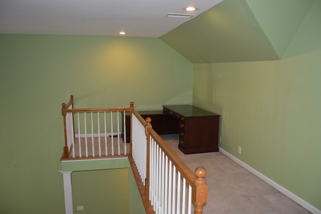 stairway featuring lofted ceiling and carpet floors