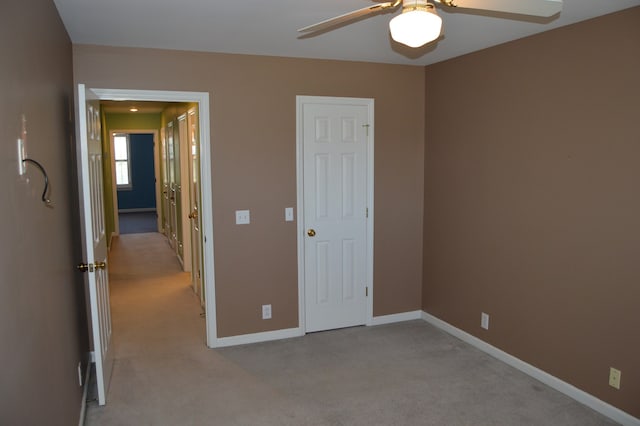 unfurnished bedroom featuring light colored carpet and ceiling fan