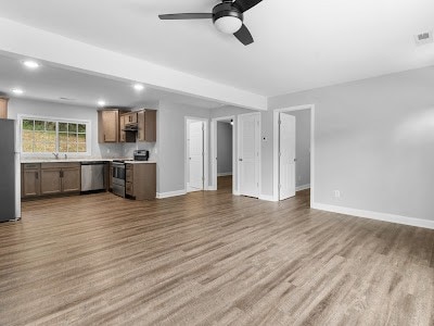 unfurnished living room featuring ceiling fan and hardwood / wood-style flooring