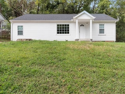 ranch-style home featuring a front lawn