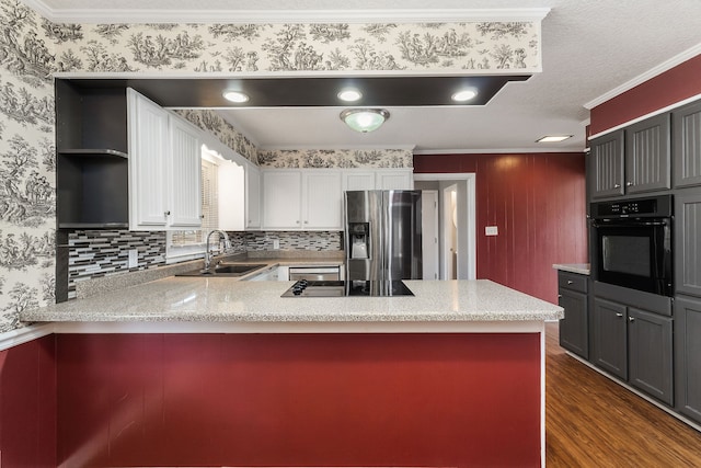 kitchen with dark wood-type flooring, sink, white cabinets, kitchen peninsula, and black appliances