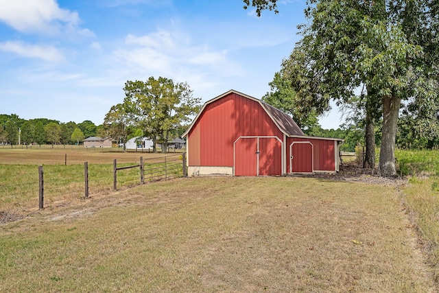 view of outbuilding featuring a rural view and a yard