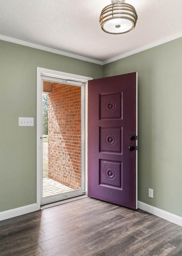 interior space featuring a textured ceiling, ornamental molding, and dark hardwood / wood-style flooring