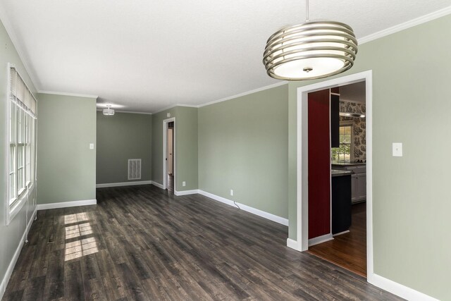 spare room featuring an inviting chandelier, ornamental molding, and dark hardwood / wood-style floors