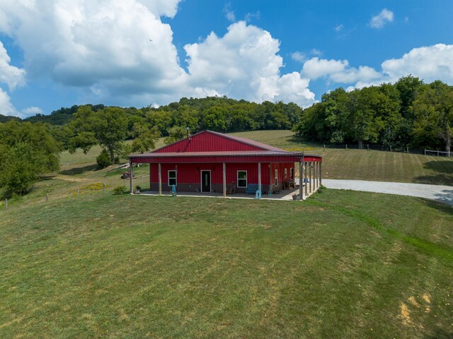 view of front of home with a front yard and a rural view