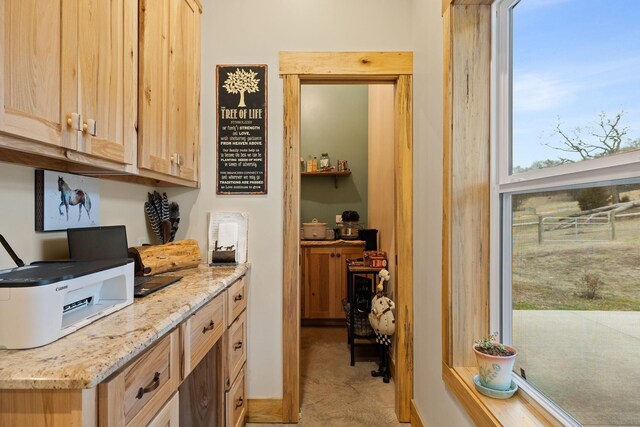 interior space with light stone counters, light brown cabinets, and carpet