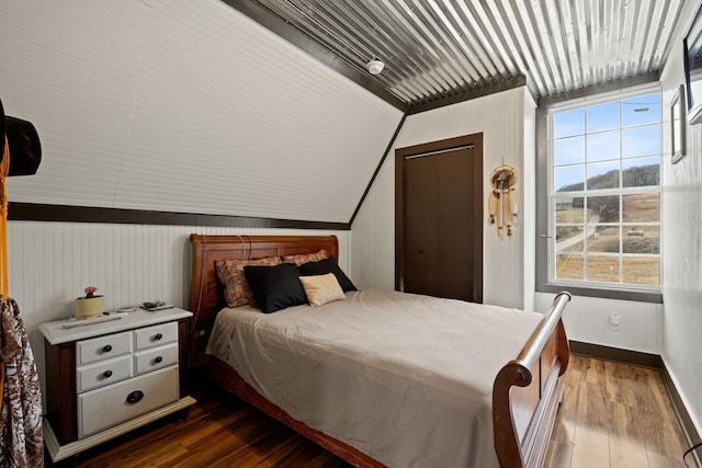 bedroom with lofted ceiling and dark wood-type flooring